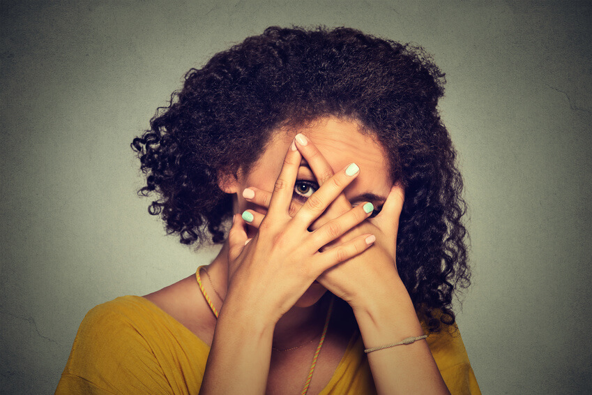 Woman covering her face with her hands to remain anonymous